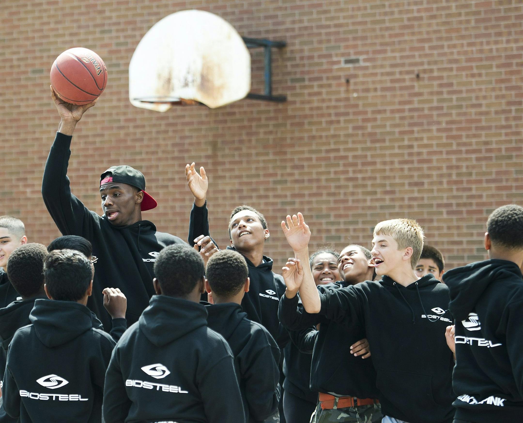 NBA first-overall draft pick Andrew Wiggins, of Canada, wearing a hat, shoots a commercial with a bunch of kids after signing an endorsement deal with BioSteel Sports Drink at his old school in Concord, Ontario, Monday, Aug. 11, 2014. (AP Photo/The Canadian Press, Nathan Denette) ORG XMIT: MIN2014082316334747