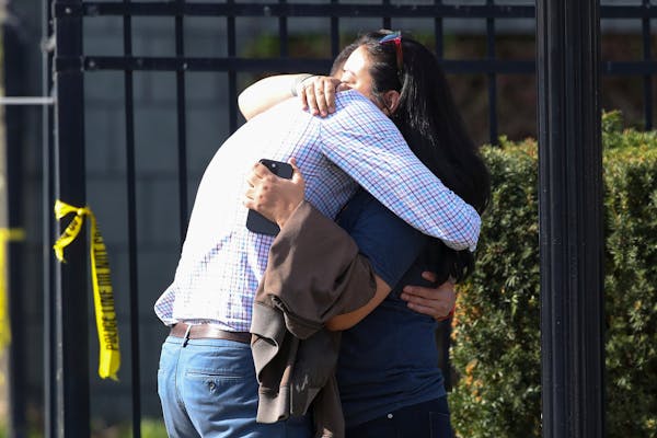FILE - Two people embraced outside of a bank building where a shooting took place in Louisville, Ky., Monday, April 10, 2023. A shooting at the bank k