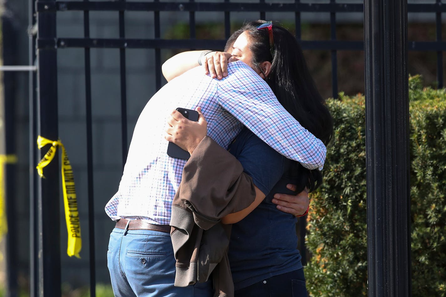 FILE - Two people embraced outside of a bank building where a shooting took place in Louisville, Ky., Monday, April 10, 2023. A shooting at the bank killed and wounded several people police said. The suspected shooter was also dead. The U.S. is setting a record pace for mass killings in 2023, replaying the horror in a deadly loop roughly once a week so far this year. The bloodshed overall represents just a fraction of the deadly violence that occurs in the U.S. annually. (Michael Clevenger/Courier Journal via AP, File)