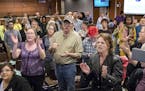 Some attendees chanted "Let them in" for a group that was initially barred from entering the meeting room because of overcapacity before the start of 