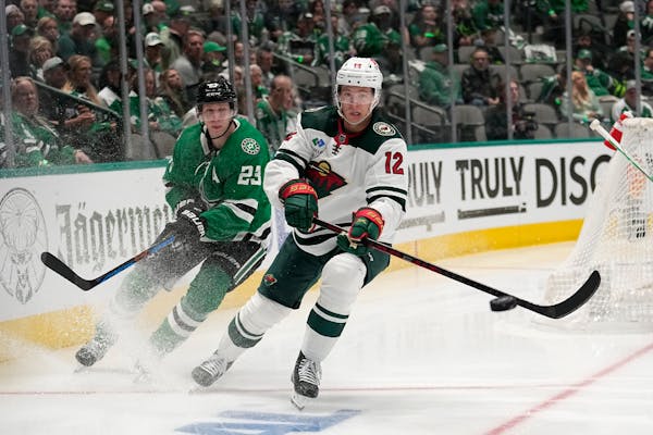 Wild winger Matt Boldy (12) made a pass as the Stars’ Esa Lindell trailed the play Monday night in Dallas.