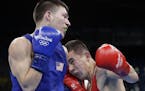 United State's Nico Miguel Hernandez, left, fights Uzbekistan's Hasanboy Dusmatov during a men's light flyweight 49-kg semifinals boxing match at the 