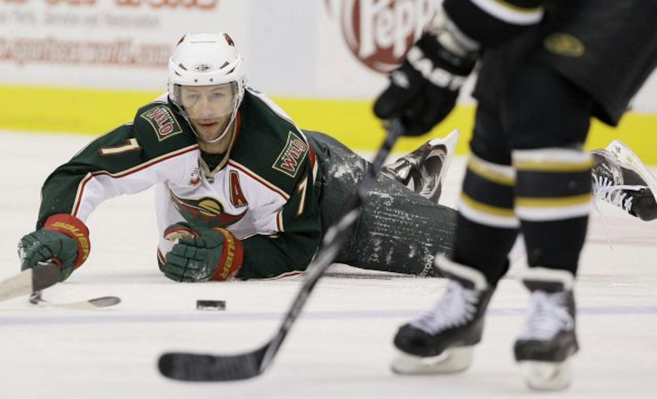 Minnesota Wild's Matt Cullen (7) attempts to reach a loose puck against the Dallas Stars' Steve Ott, front, in the first period of an NHL hockey game Friday, March 11, 2011, in Dallas.