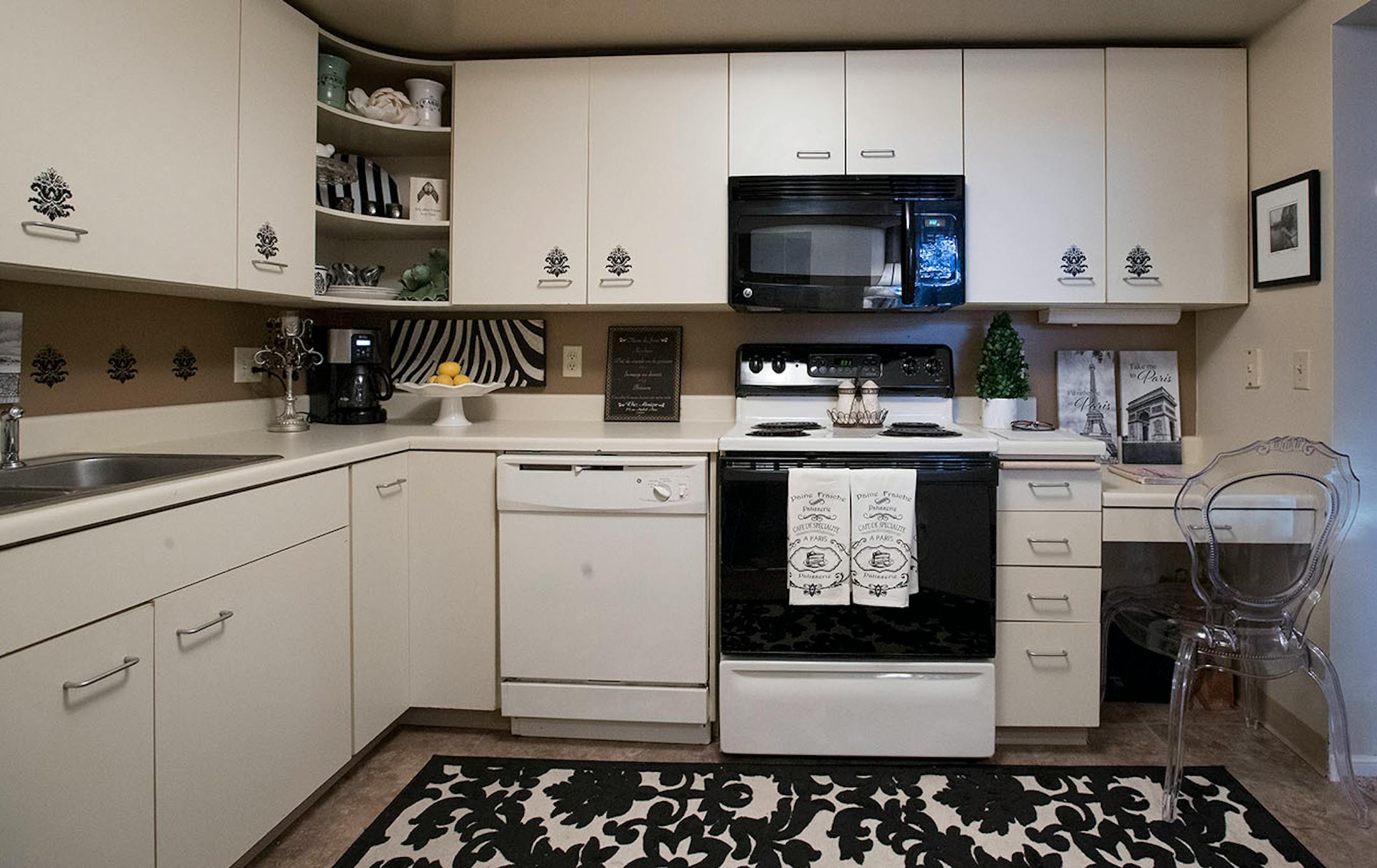 Peel-and-stick decals in a fleur-de-lis pattern add visual interest to generic cabinets and backsplash.