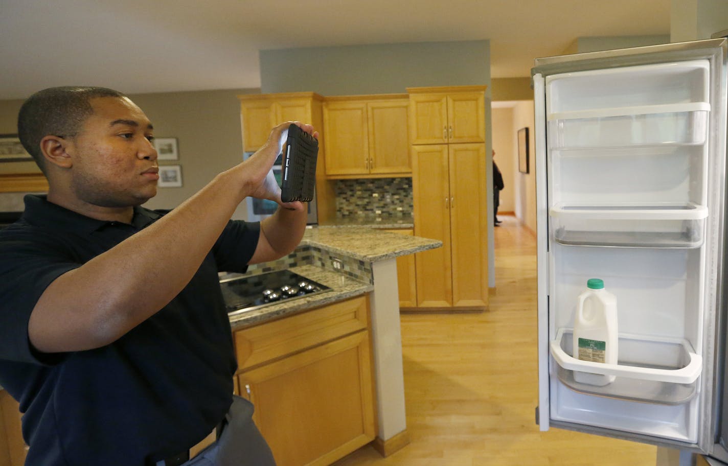 Nicholas Harris inside sales team lead at Renters Warehouse shot a video as he demonstrated a home inspection in Minnetonka on Thursday. ] CARLOS GONZALEZ cgonzalez@startribune.com - September 24, 2015, Minnetonka, MN, Twin Cities-based Renters Warehouse, one of the biggest national managers of single family houses, has been sold to a private equity firm that plans to expand its national presence.