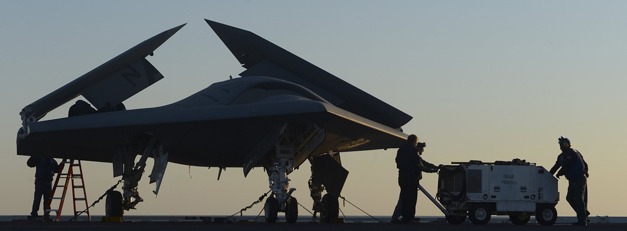 An image provided by the US Navy shows sailors working on an X-47B Unmanned Combat Air System (UCAS) at dawn aboard the aircraft carrier USS George H.W. Bush Tuesday, May 14, 2013. The drone was launched off the George H.W. Bush to be the first aircraft carrier to catapult launch an unmanned aircraft from its flight deck. (AP Photo/U.S. Navy photo by Mass Communication Specialist 2nd Class Timothy Walter) ORG XMIT: MIN2013051614154043