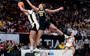 Taylor Woodson (21), making a play for Michigan against Iowa in the Big Ten tournament at Target Center, entered the transfer portal and will play for