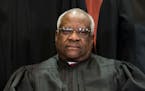 FILE -- Associate Justice Clarence Thomas joins the rest of the Supreme Court justices in sitting for a group photo in Washington on Nov. 30, 2018. On
