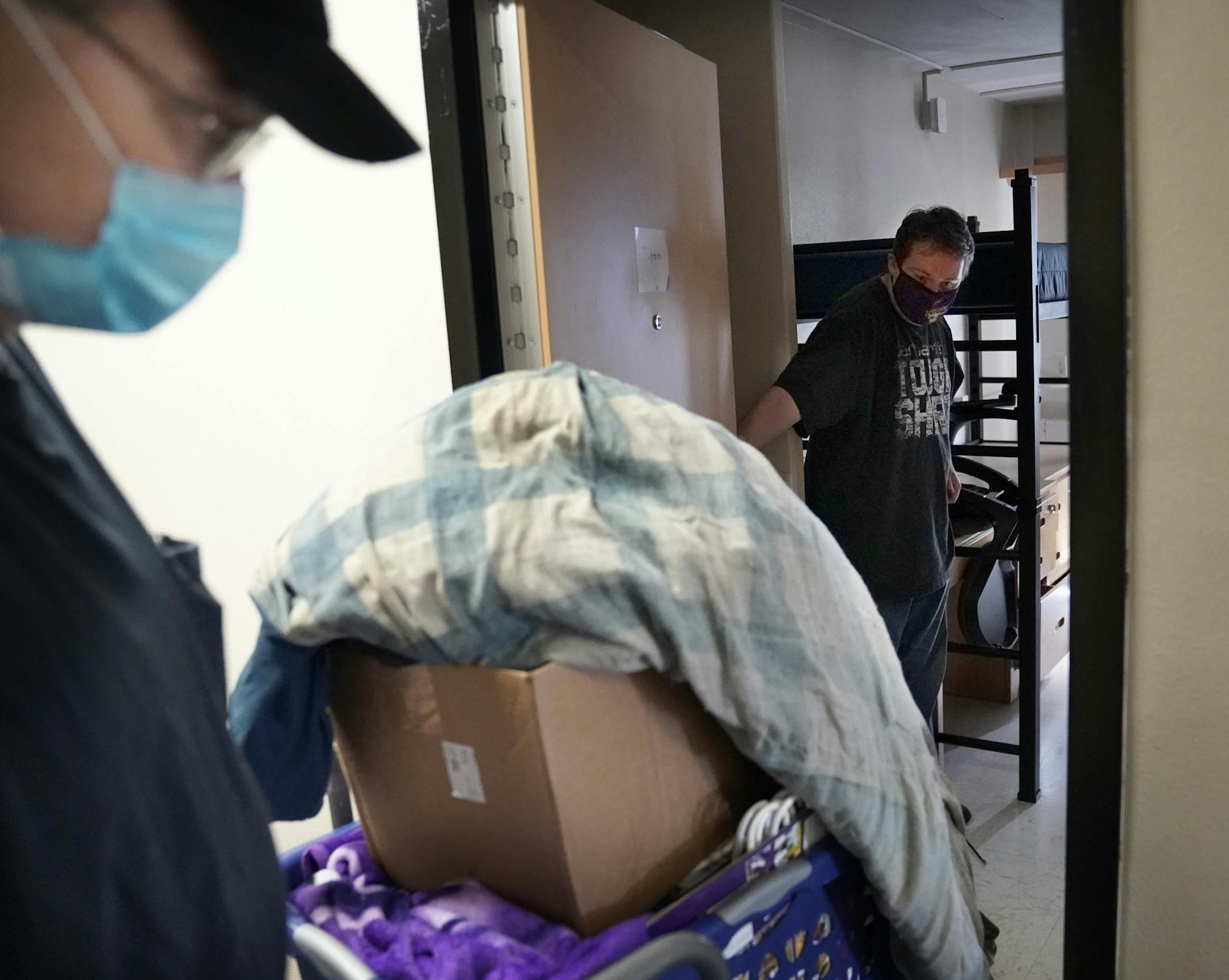 Students began moving into dormitories at Minnesota State University-Mankato Thursday where Justin Fuchs, 33, right, held the door for his father Tim Fuchs of Blue Earth, who was helping his non-traditional student son moved into Crawford Residence at Minnesota State.