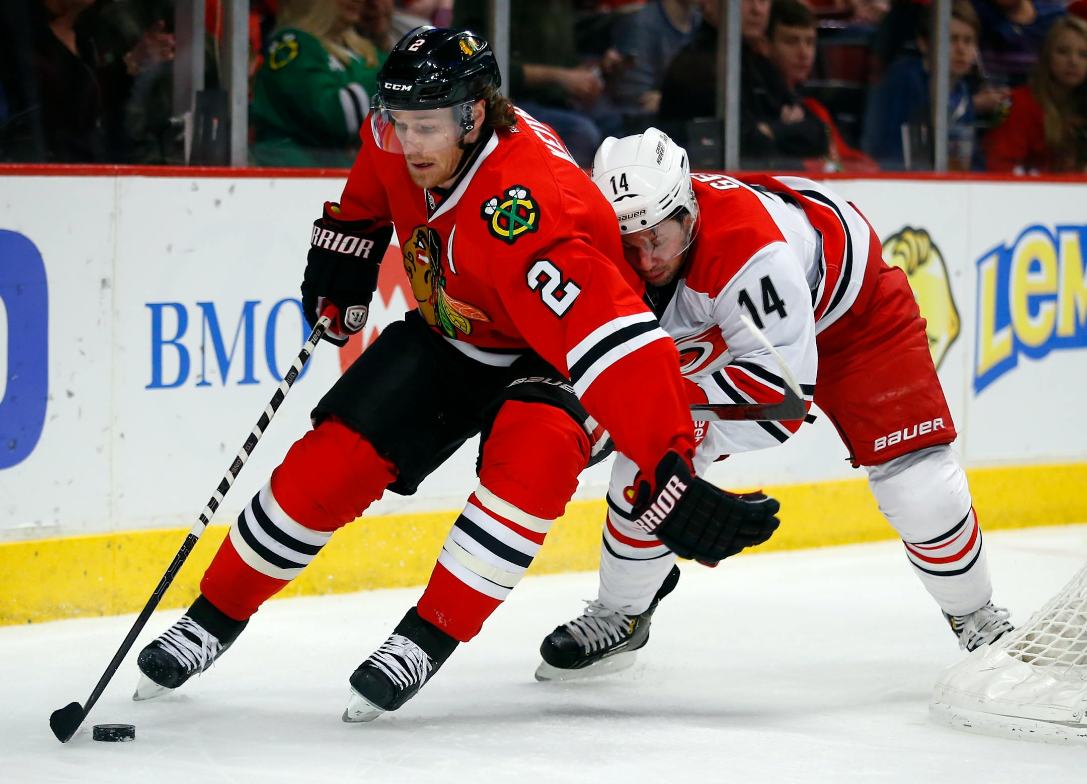 Chicago Blackhawks defenseman Duncan Keith (2) shields the puck from Carolina Hurricanes left wing Nathan Gerbe (14) during the first period of an NHL hockey game in Chicago, Friday, March 21, 2014. (AP Photo/Jeff Haynes)