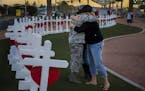 Sharon Black of Las Vegas, right, hugs Airmen First Class Williams of the U.S. Air Force after they were both overcome with emotion while viewing wood
