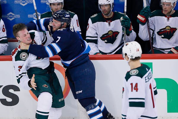 Winnipeg Jets' Ben Chiarot (7) and Minnesota Wild's Nick Seeler (36) mixed it up during the third period of Game 2.