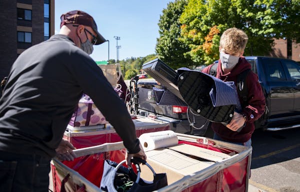 (Left) Mike Reese helped his son, Jacob, unload the car as they moved him into Ianni Hall at UMD on Thursday.