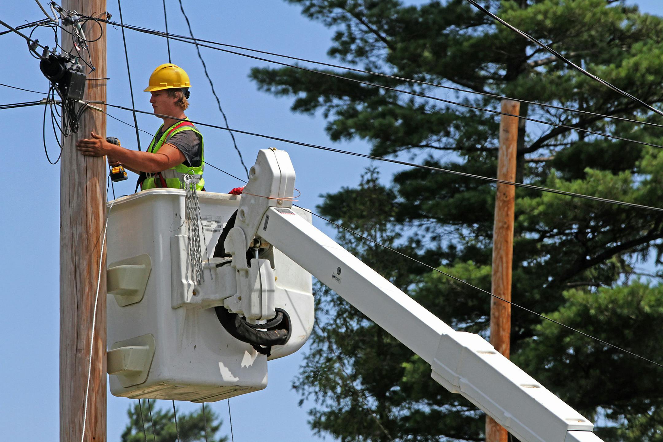 Seth Kern, with Lake States Construction, a sub-contractor of Lake Connections, readied telephone poles in Two Harbors to string stainless steel strand cables from which fiber optic cable will be lashed to on 7/31/12. By the time the communications project is done in 2014 around 2000 miles of fiber optic cable will be strung, connecting customers with broadband internet, video and telephone service. ] Bruce Bisping/Star Tribune bbisping@startribune.com ORG XMIT: MIN2014022618253324