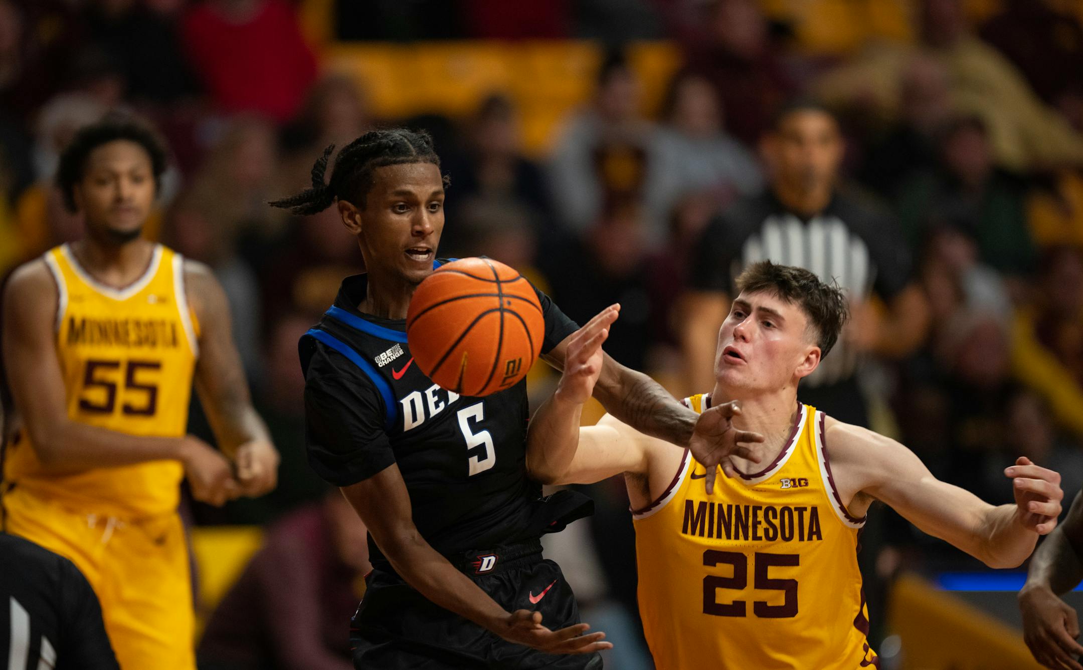 DePaul Blue Demons guard Philmon Gebrewhit (5) and Minnesota Gophers guard Will Ramberg (25) both sought control of an errant pass in the second half.