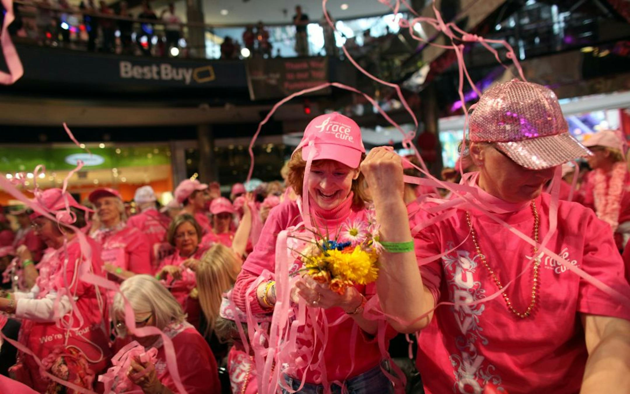 Breast cancer survivors Deborah Tavernier, left, and Mary Jane Kruse, right, got tangled in confetti as they participated in the survivor ceremony at the Susan G. Komen Race for the Cure Sunday at the Mall of America.