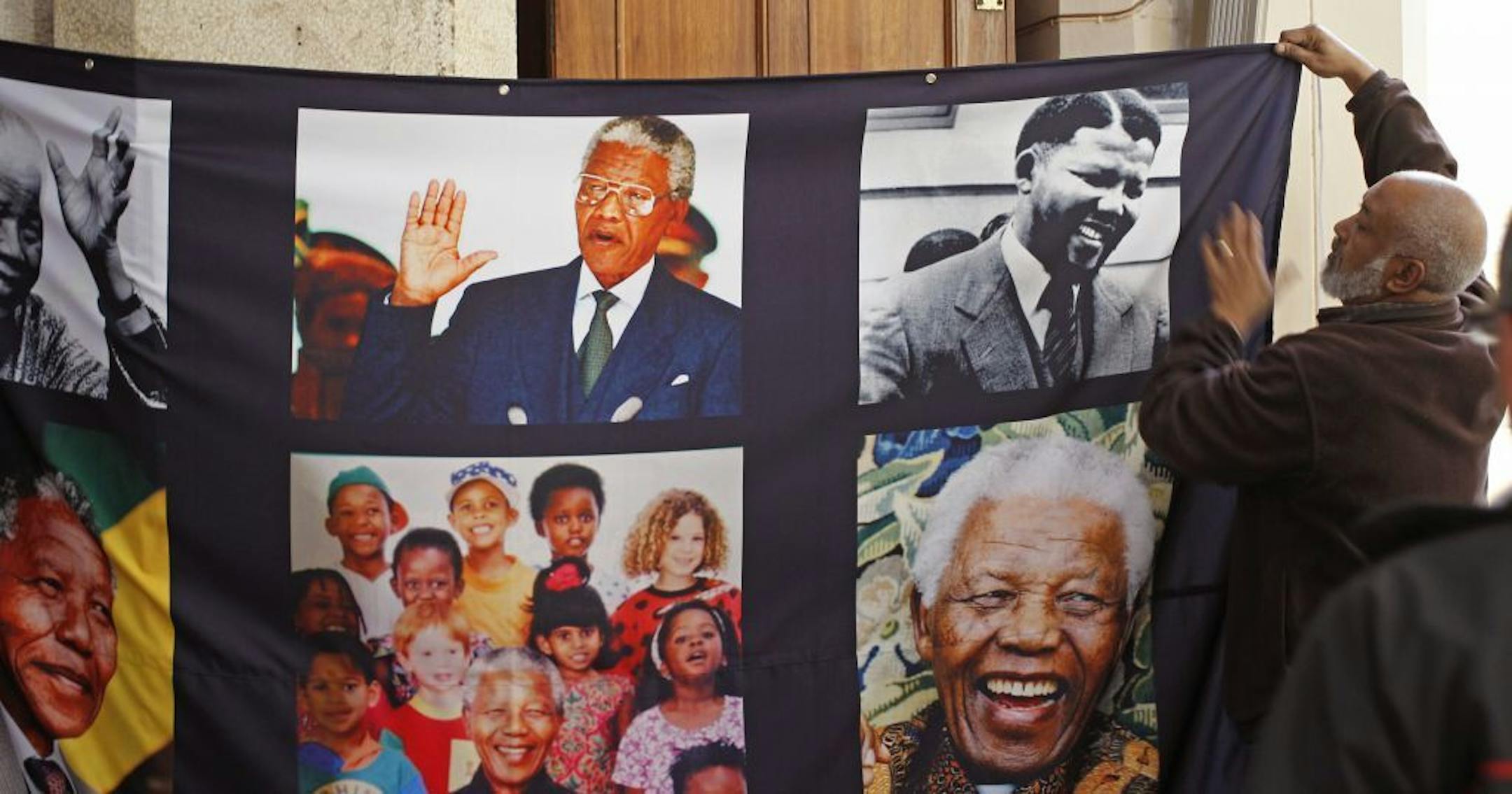 A banner with images of former South African president Nelson Mandela, is hung inside the St. George�s Cathedral in Cape Town, South Africa, Wednesday, July 17, 2013. As Nelson Mandela lies critically ill in a Pretoria hospital, the world is preparing to celebrate his 95th birthday on Thursday, a day declared by the United Nations as a way to recognize the Nobel Prize winner's contribution to reconciliation.