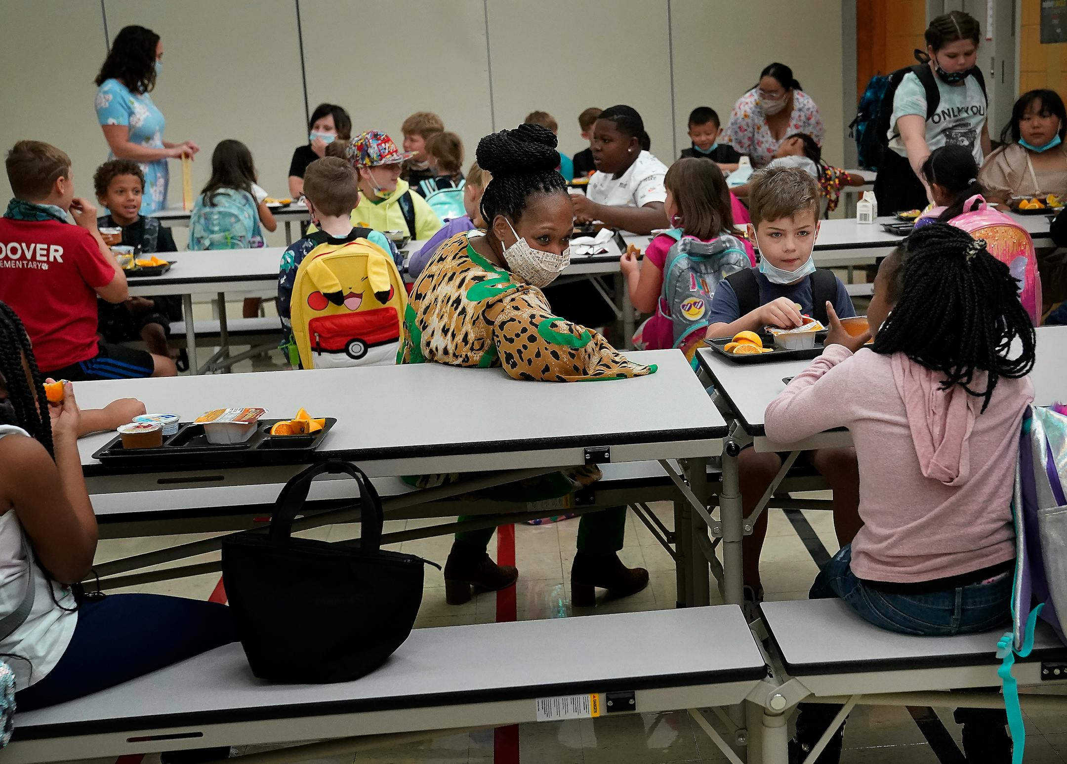 New Hoover Elementary School principal Keisha Davis chatted with first graders Malaika Naimodu, right to left, and Zayne Carlson as they ate breakfast before the start of the first day of school Tuesday in Coon Rapids.   ]