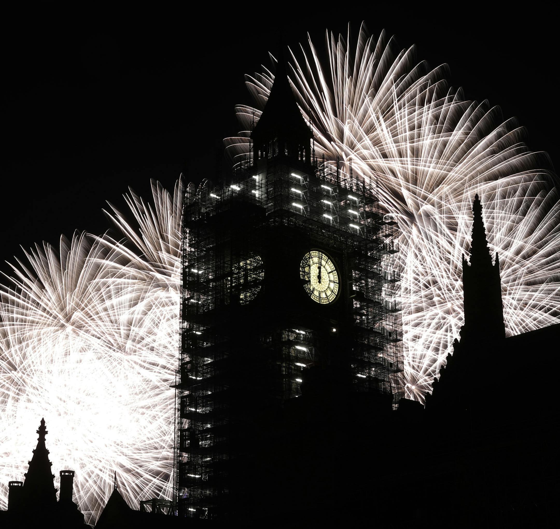 Fireworks explode over the River Thames behind the Elizabeth Tower which contains the bell know as "Big Ben", at the Houses of Parliament in London, as New Year's celebrations take place after midnight, Monday, Jan. 1, 2018. Scaffolding stands erected around the Elizabeth Tower for repairs, with the last extensive conservation works taking place more than 30 years ago. (AP Photo/Matt Dunham)