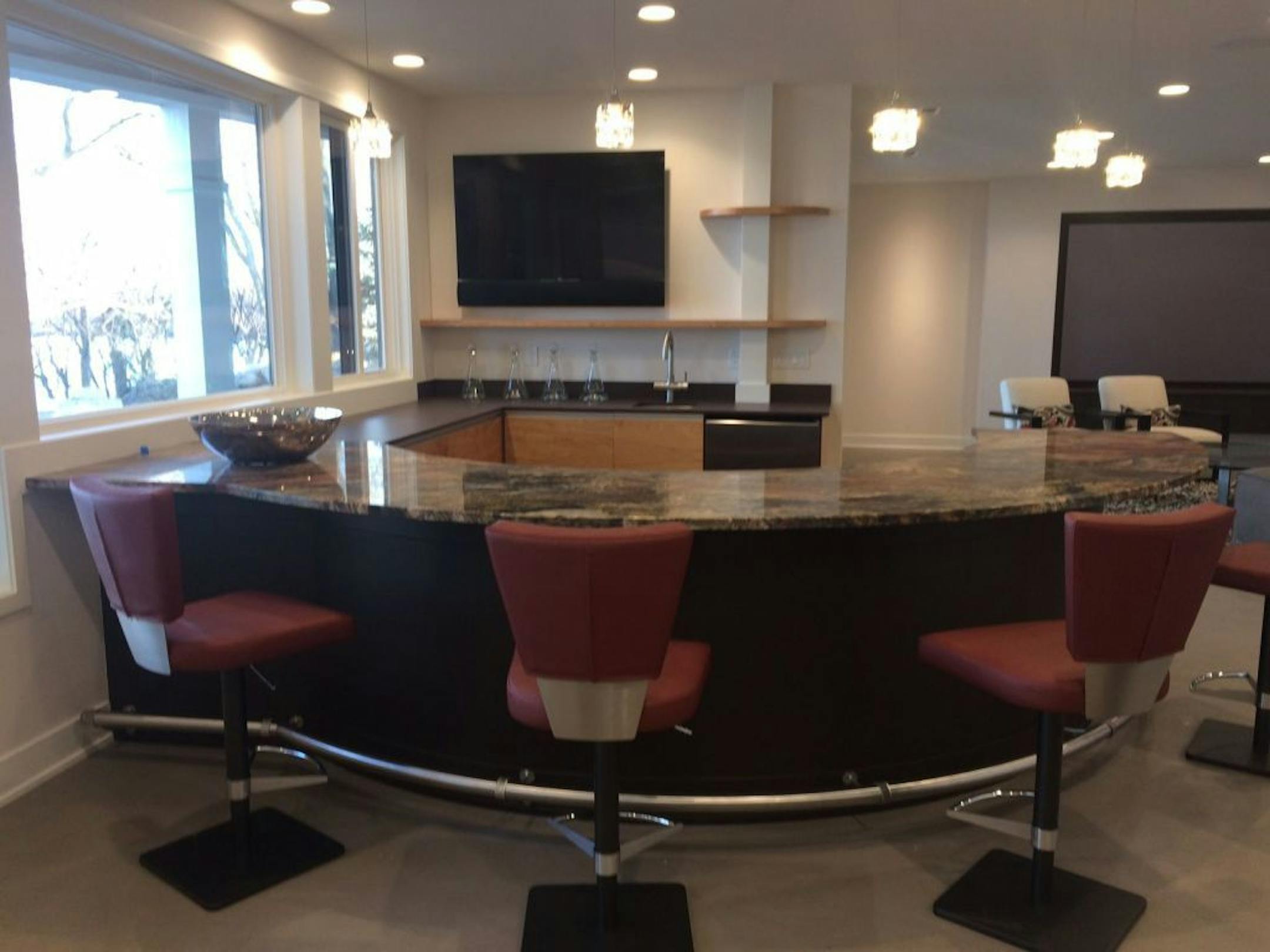A full "summer" kitchen on the lower level features a curved granite-topped wet bar.