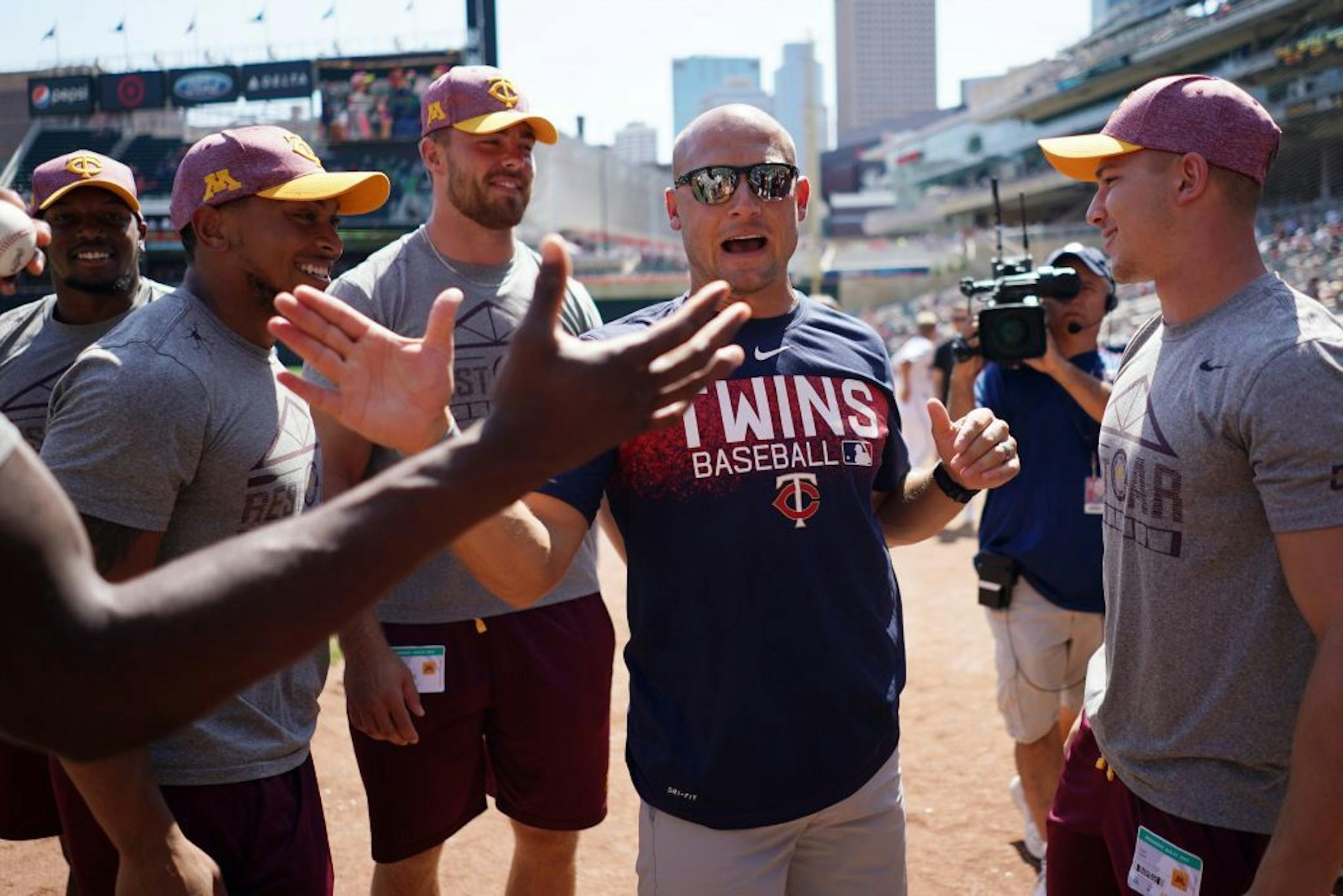 Gophers wide receiver Clay Geary (18), right, smiled after finding out he was a scholarship recipient as head coach P.J. Fleck gave high fives all around ahead of Wednesday's Twins game.
