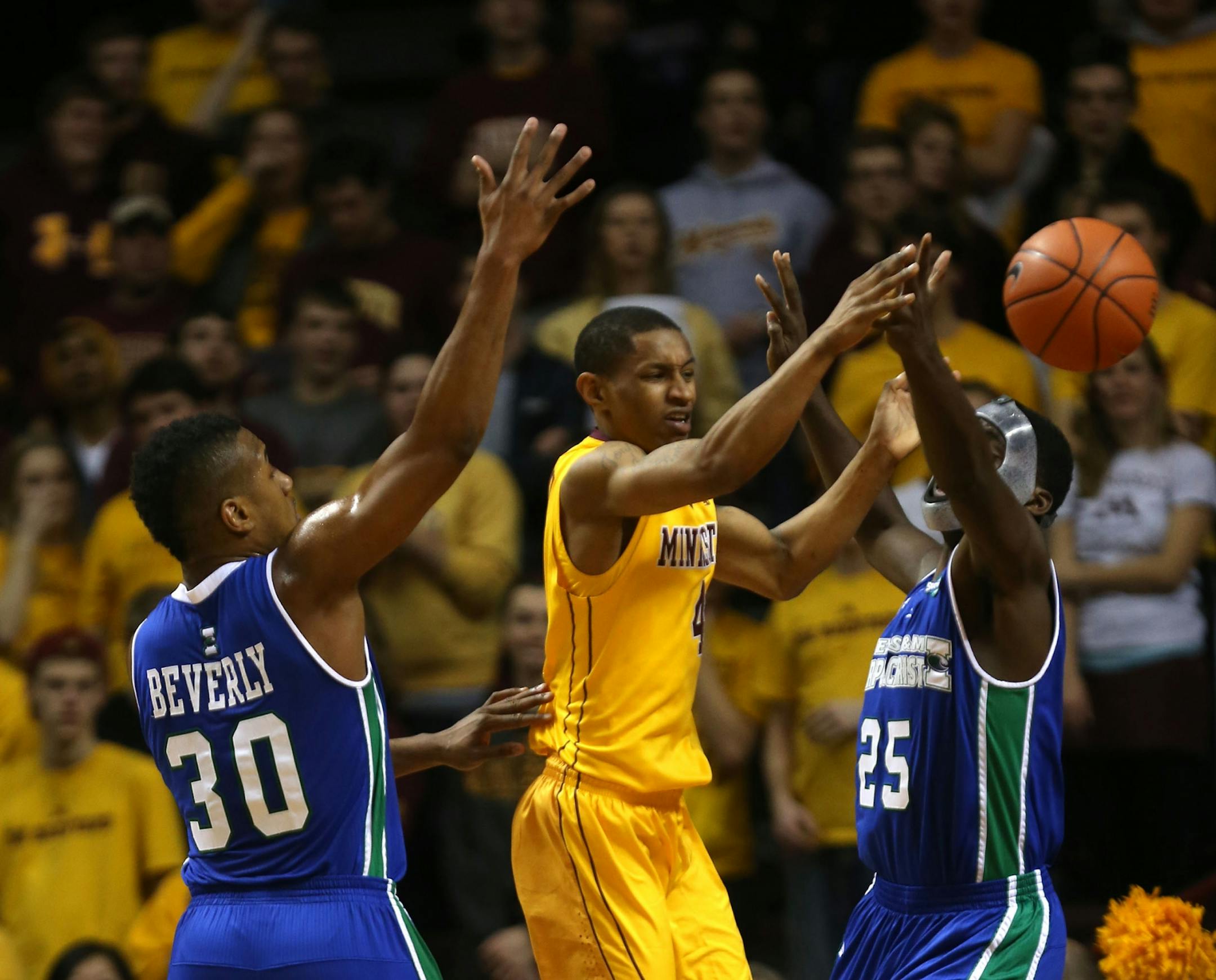 Gophers DeAndre Mathieu made a pass after driving to the basket splitting TAMCC defenders during the first half at Williams Arena in Minneapolis Saturday, December 28, 2013.