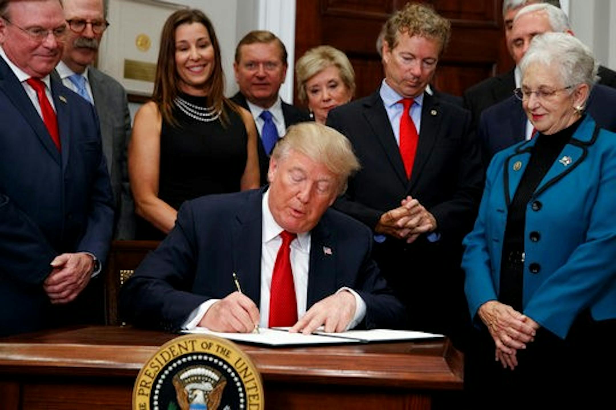 President Donald Trump signs an executive order on health care in the Roosevelt Room of the White House, Thursday, Oct. 12, 2017, in Washington. (AP Photo/Evan Vucci)