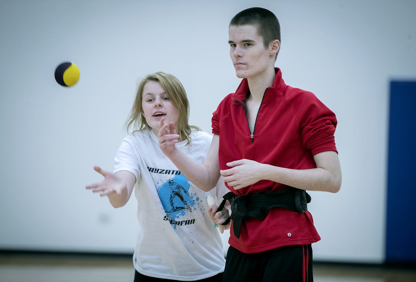 Wayzata senior Amelia Walker, left, helped Sam Foley with a throwing and catching drill during Unified PE at Wayzata High School, Thursday, January 18, 2018 in Plymouth, MN. Wayzata is in its second year of a wildly successful program called Unified PE, which brings together general students with special needs students in the same physical education class. It's so popular that the class fills up fast and they've developed a Unified club program after school. ] ELIZABETH FLORES &#xef; liz.flores@