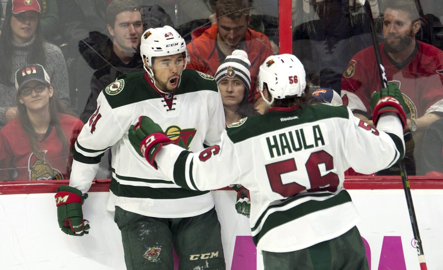 Minnesota Wild defenceman Matt Dumba, left, celebrates his game-winning goal with teammate center Erik Haula during overtime in an NHL hockey game Sunday, Nov. 13, 2016, in Ottawa, Ontario. (Adrian Wyld/The Canadian Press via AP)