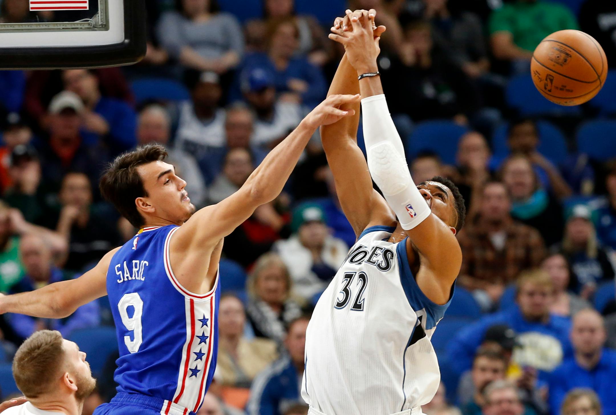 Philadelphia 76ers' Dario Saric, left, of Croatia, breaks up a rebound try by Minnesota Timberwolves' Karl-Anthony Towns in the first quarter of an NBA basketball game Thursday, Nov. 17, 2016, in Minneapolis. (AP Photo/Jim Mone)