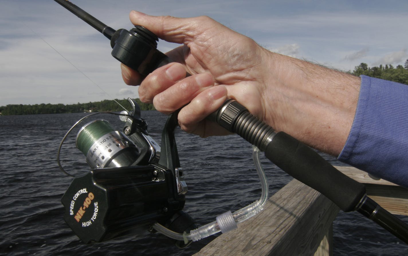 Photo by Doug Smith/Star Tribune; June 12, 2014; Dr. Roland Kehr shows how his M-POW-R motorized reel works. A push button on the rod (near his right thumb) activates the motor, which is powered by a battery pack attached to Keh'r waist. A controller adjusts the speed of the retrieve. Kehr developed the device to help disabled anglers fish. "It works,'' he said.