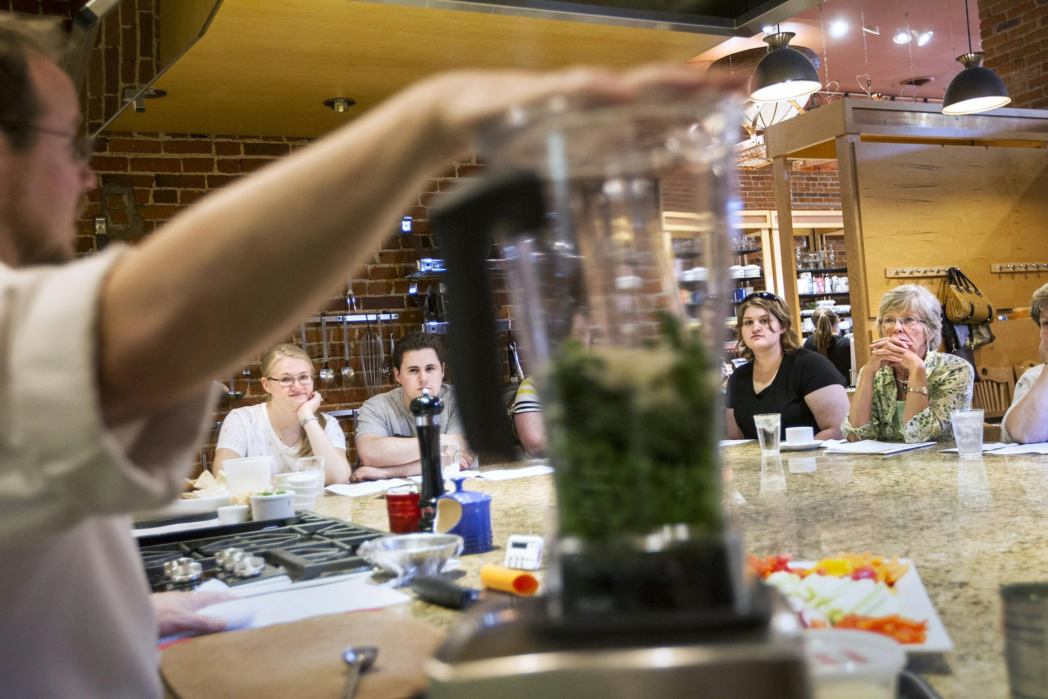 Wade Gregory, foreground, teaches a Lunch Counter demo class at Cooks of Crocus Hill in Stillwater June 27, 2014. Customers learn how to make recipes that they then enjoy for lunch. (Courtney Perry/Special to the Star Tribune)