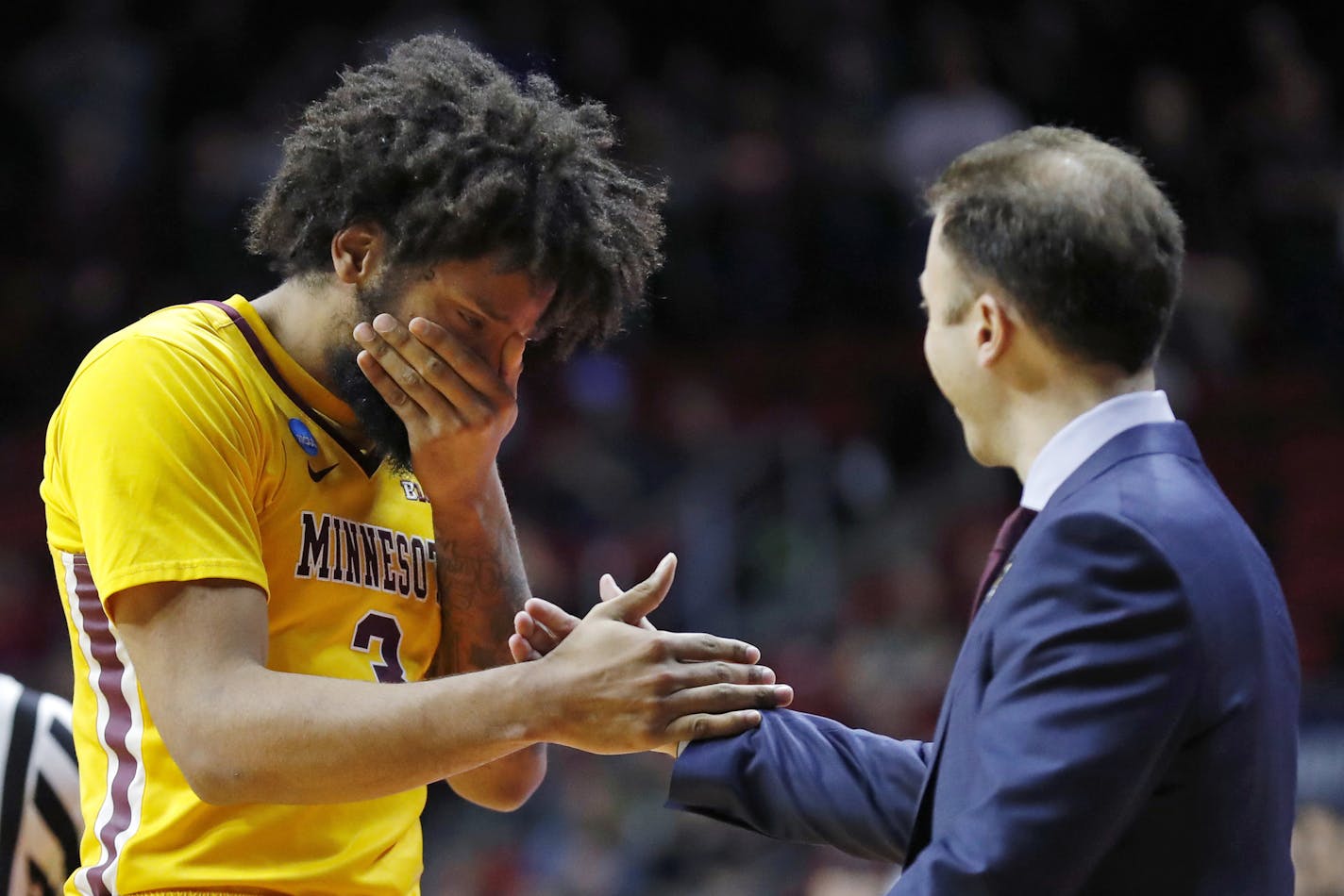 Minnesota forward Jordan Murphy, left, reacts with head coach Richard Pitino as he is taken out of the game at the end of a second round men's college basketball game against Michigan State in the NCAA Tournament, Saturday, March 23, 2019, in Des Moines, Iowa. Michigan State won 70-50. (AP Photo/Charlie Neibergall)