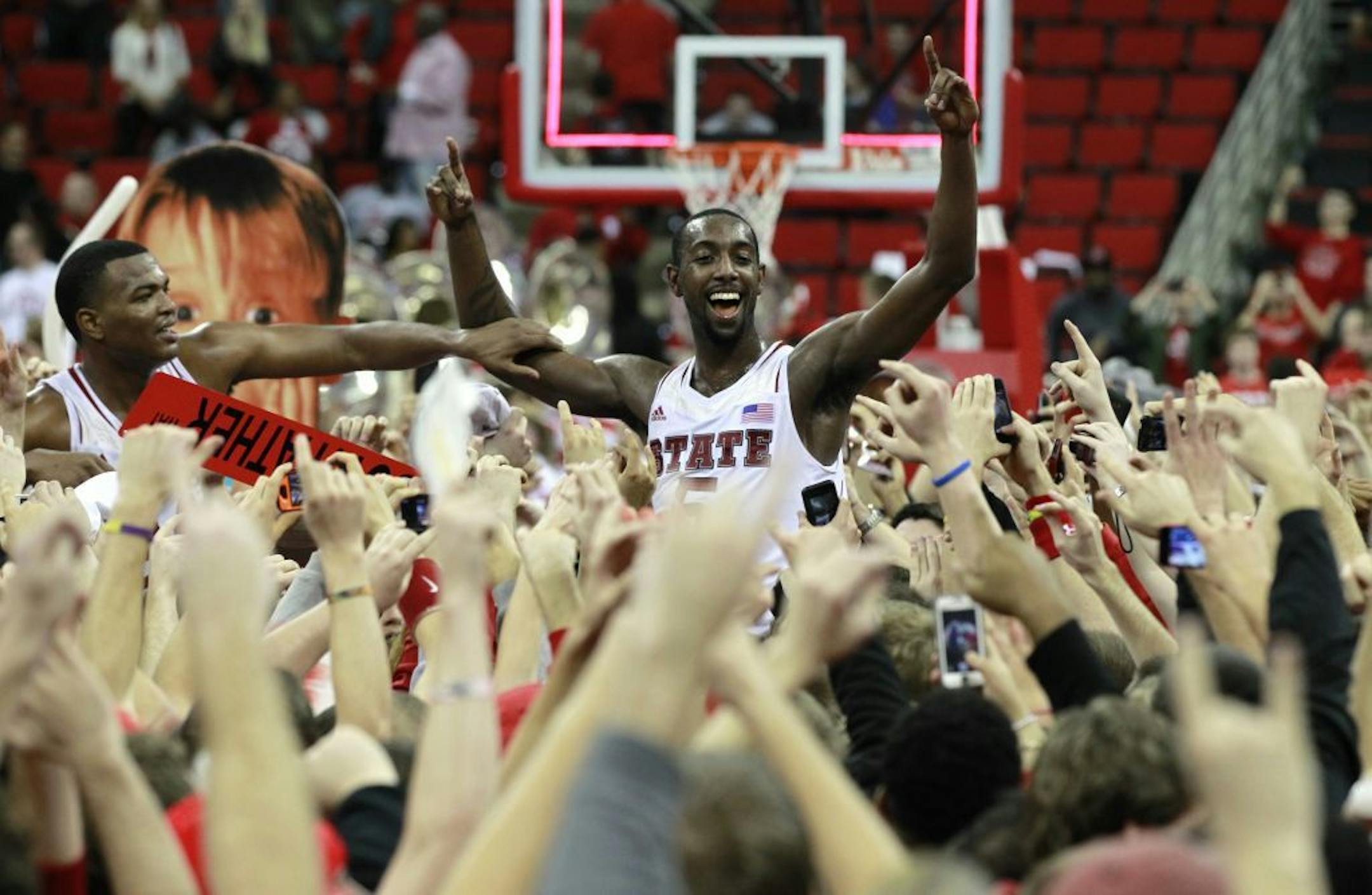 North State's C.J. Leslie (5), center, and T.J. Warren (24) celebrate with the fans after N.C. State beat Duke, 84-76, at PNC Arena in Raleigh, North Carolina, Saturday, January 12, 2013.