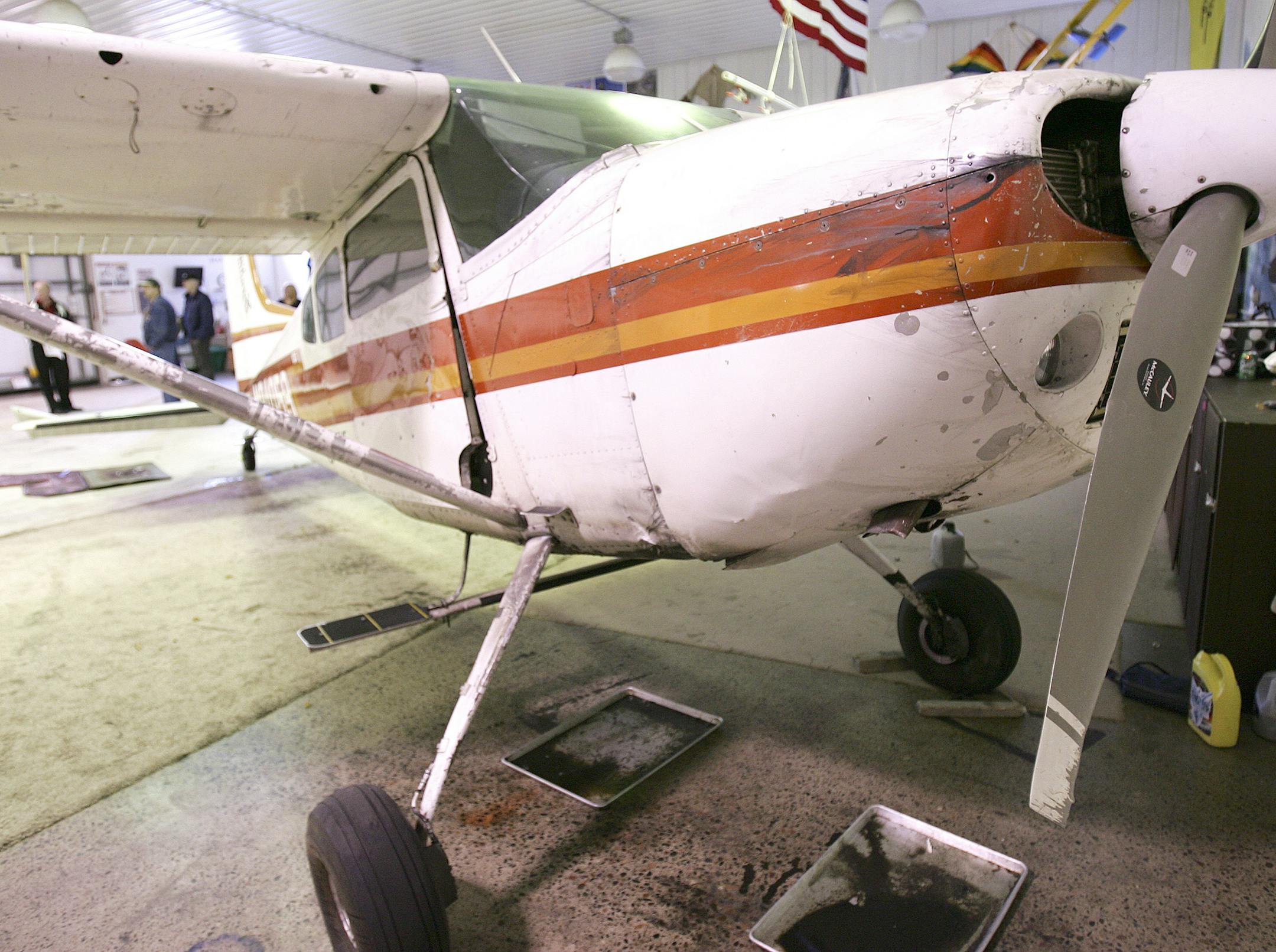 The plane that survived Saturdayís midair collision sits in Skydive Superiorís hanger, Sunday, Nov. 3, 2013, dripping oil. (AP Photo/The News-Tribune, Steve Kuchera)
