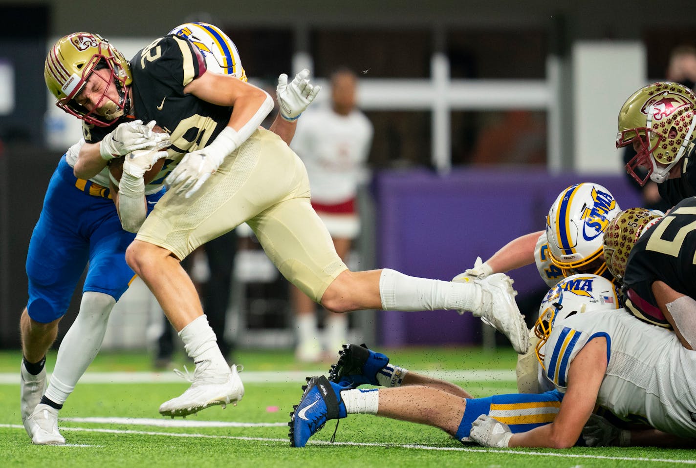 Lakeville South High School running back Carson Hansen (28) powers through multiple defenders in the second half against St. Michael-Albertville High School in a 6A football state tournament semi-final game Friday, Nov. 19, 2021 in U.S. Bank Stadium in Minneapolis. ]