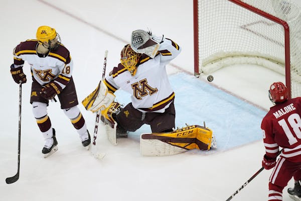 Minnesota Golden Gophers goaltender Mat Robson (40) was unable to make the save off as shot by Wisconsin Badgers defenseman Peter Tischke (6) in the t