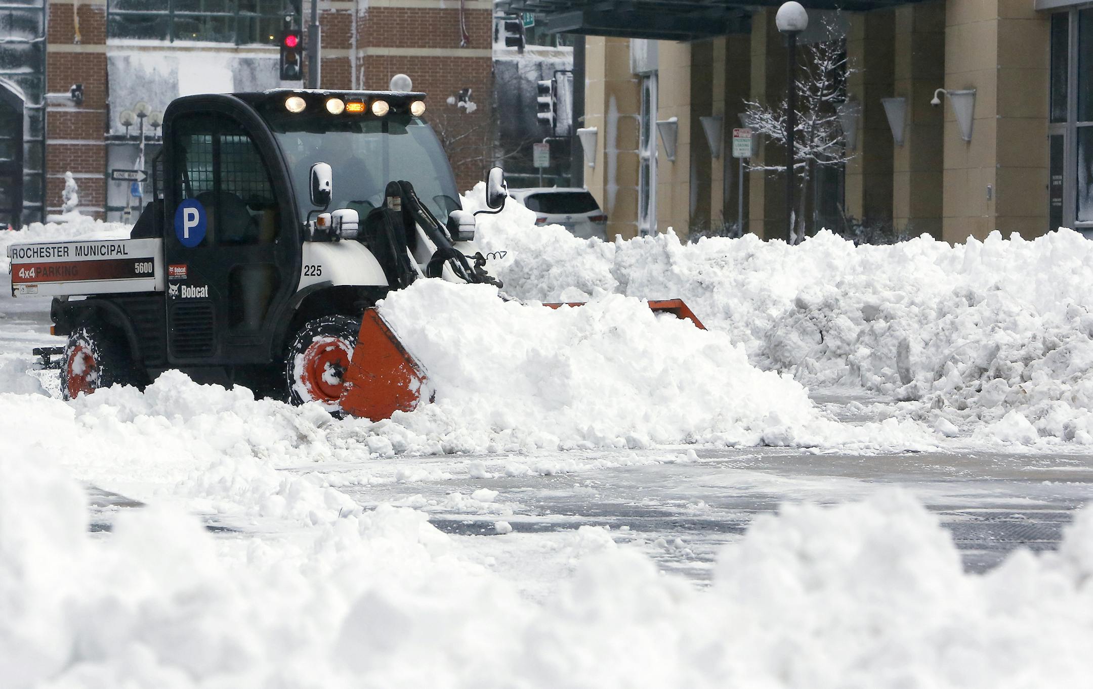 A Rochester Municipal Parking crew clears snow around the First Street Ramp in downtown Rochester, Minn., on Friday, Feb. 24, 2017. Forecasters expected additional snow through Friday night. The heavy snow missed the Twin Cities in Minnesota and the Milwaukee metro area in Wisconsin. (Andrew Link/The Rochester Post-Bulletin via AP)