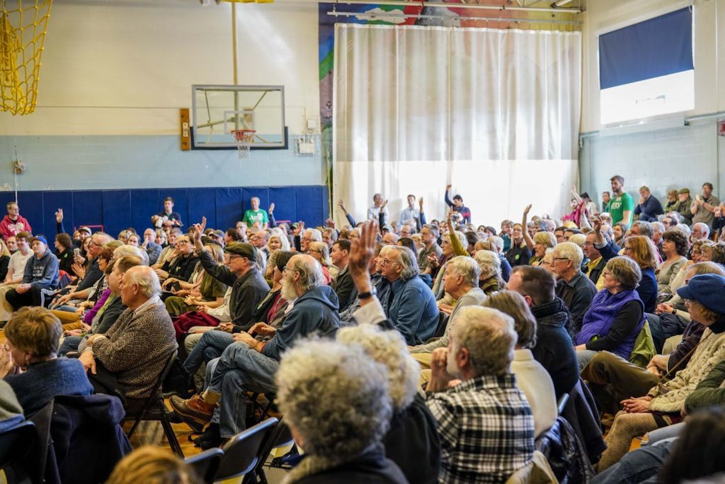 Audience members raise their hands to ask questions of Sen. Amy Klobuchar (D-Minn.) during a town hall in Rye, N.H., March 23, 2019. At events across early primary states, voters asked about health care and school shootings and immigration.