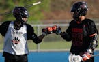 Twin brothers Dayton, left, and Dante Buck fist-bumped before a lacrosse game against Eastview High School Thursday.
