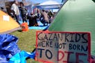 A sign calling attention to the conflict in Gaza rests against a tent at an encampment on the Massachusetts Institute of Technology campus in Cambridg