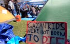 A sign calling attention to the conflict in Gaza rests against a tent at an encampment on the Massachusetts Institute of Technology campus in Cambridg
