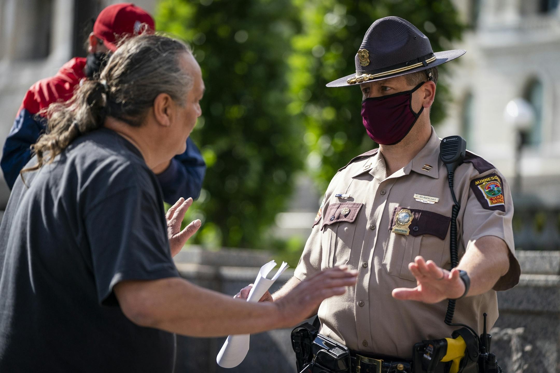 Mike Forcia, left, talked with a Minnesota State Trooper about safely taking the statue down with no arrests.
