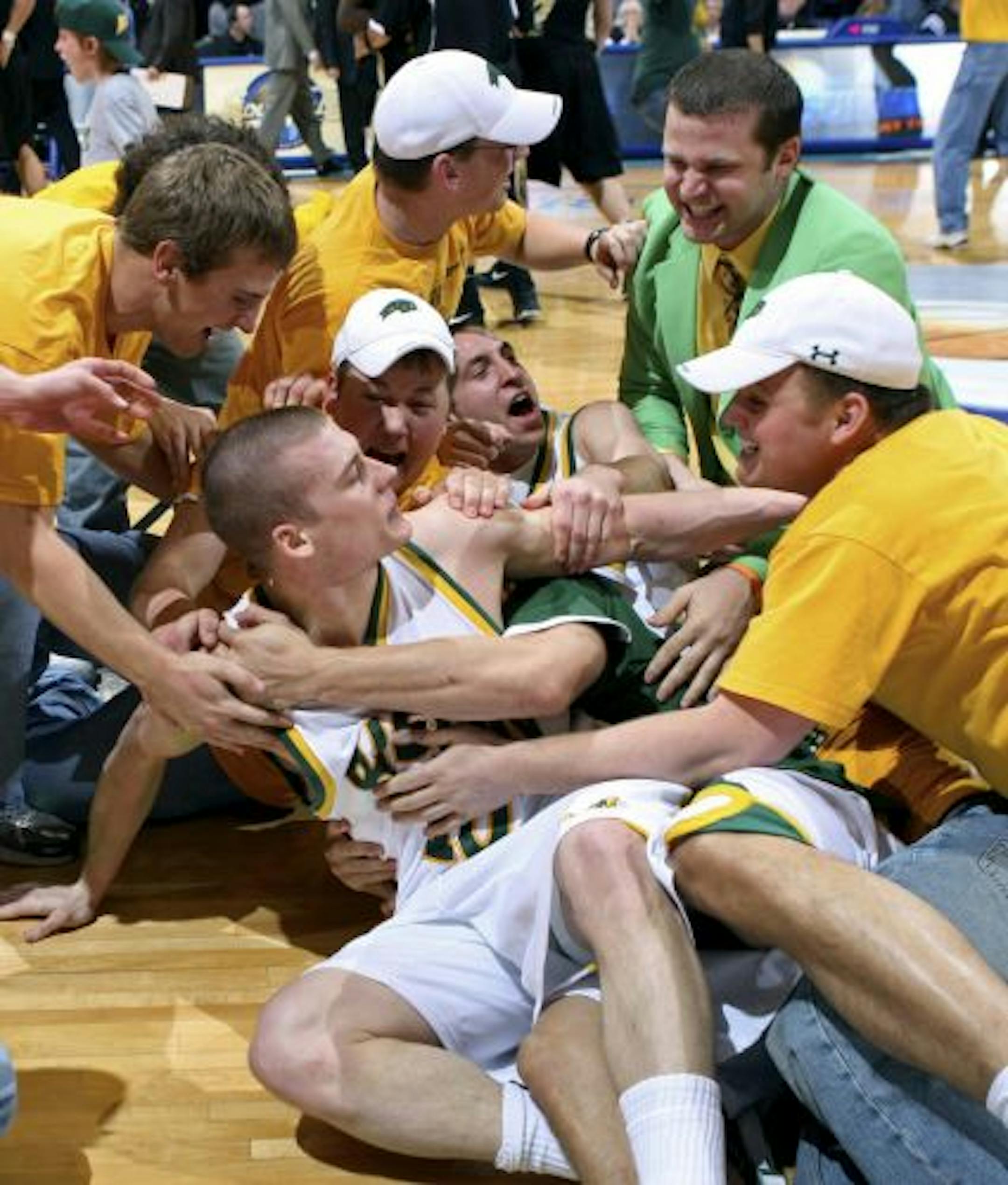 North Dakota State guard Ben Woodside, front, got stormed by a group of fans after North Dakota State's 66-64 victory over Oakland in the Summit League tournament title game.