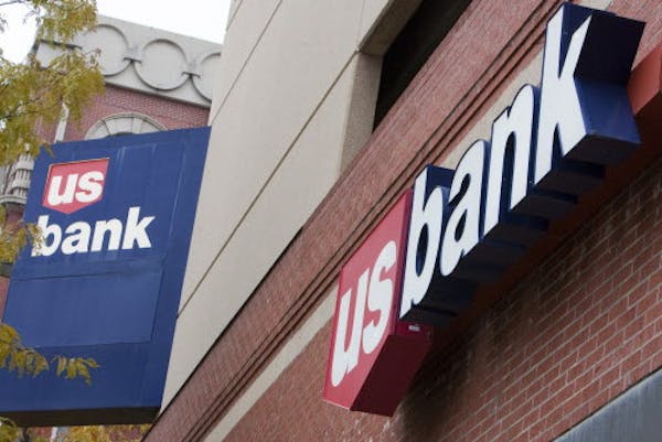 FILE - In this Oct. 20, 2009 file photo, signs on a US Bank branch in Omaha, Neb., are shown. U.S. Bancorp said Wednesday, Jan. 19, 2011, its fourth-q