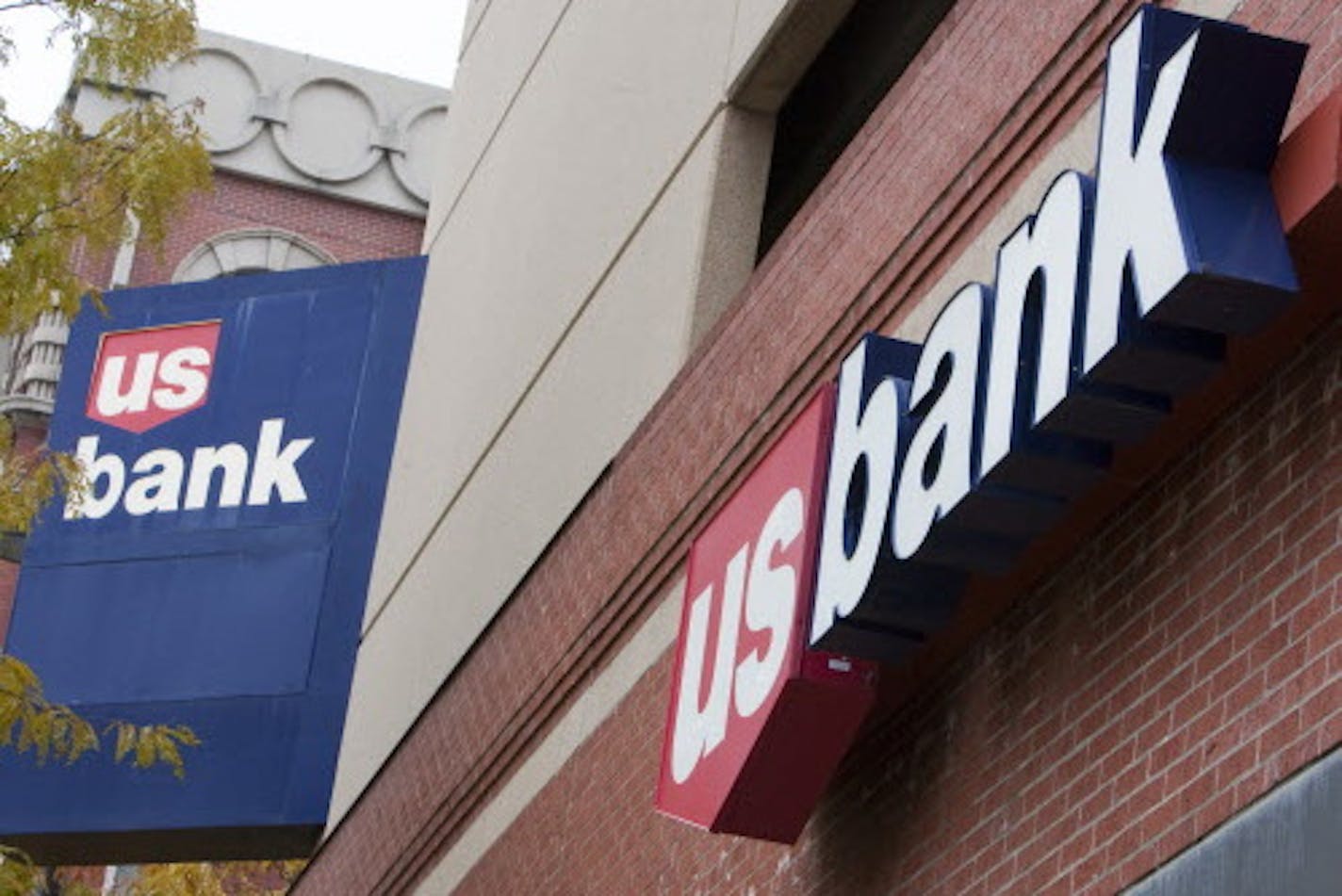 FILE - In this Oct. 20, 2009 file photo, signs on a US Bank branch in Omaha, Neb., are shown. U.S. Bancorp said Wednesday, Jan. 19, 2011, its fourth-quarter profit jumped 64 percent as it wrote off fewer bad loans. (AP Photo/Nati Harnik, File)