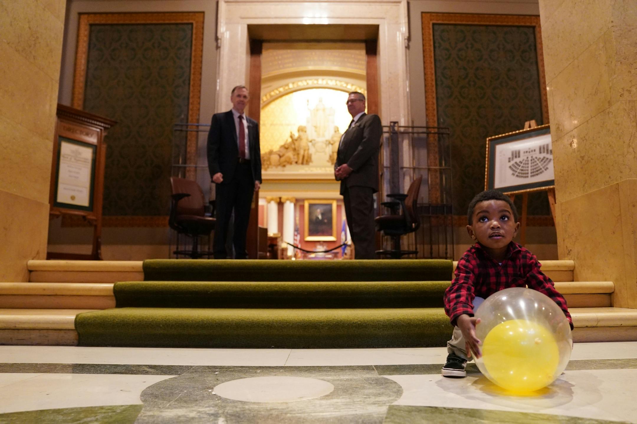 Zavi Ruegemer, 2, of Orono played with a balloon as he waited with his mom Julie from the organization Moms Demand Action to greet state house representatives before the state of the legislative session Tuesday.