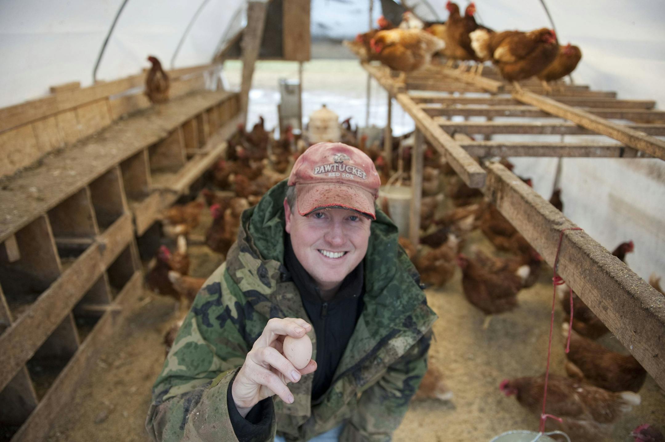 Locally Laid Egg Company small business owner Jason Amundsen shows off a pasture-raised egg from one of his ëLolaí hens in Wrenshall, Minn., Monday, Nov. 4, 2013. Jason was named a finalist for Intuitís Small Business Big Game competition, which will award a 30-second television advertisement that will air during the Super Bowl on Feb. 2. (Photo by Craig Lassig/Invision for Intuit, Inc./AP Images)