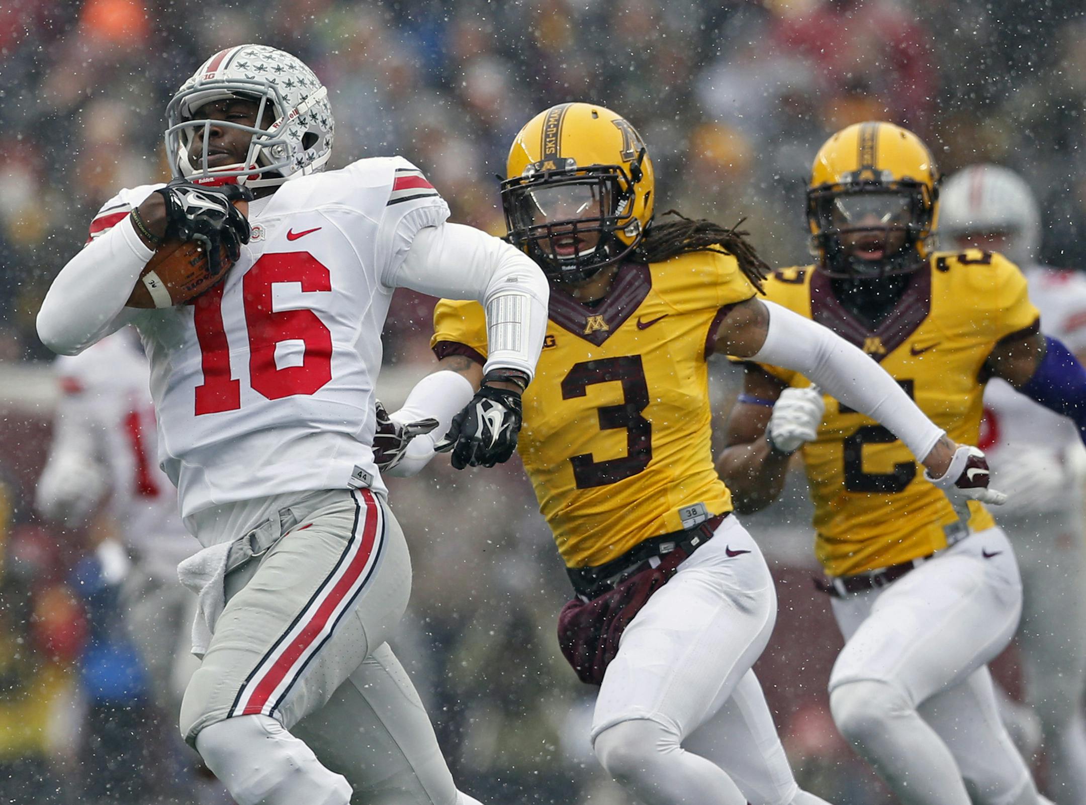 Ohio State Buckeyes quarterback J.T. Barrett (16) scores on a touchdown run against Minnesota Golden Gophers defensive back Derrick Wells (3) during the first quarter at TCF Bank Stadium on Nov. 15, 2014 in Minneapolis. The Buckeyes won 31-24. (Kyle Robertson/Columbus Dispatch/MCT) ORG XMIT: 1160109