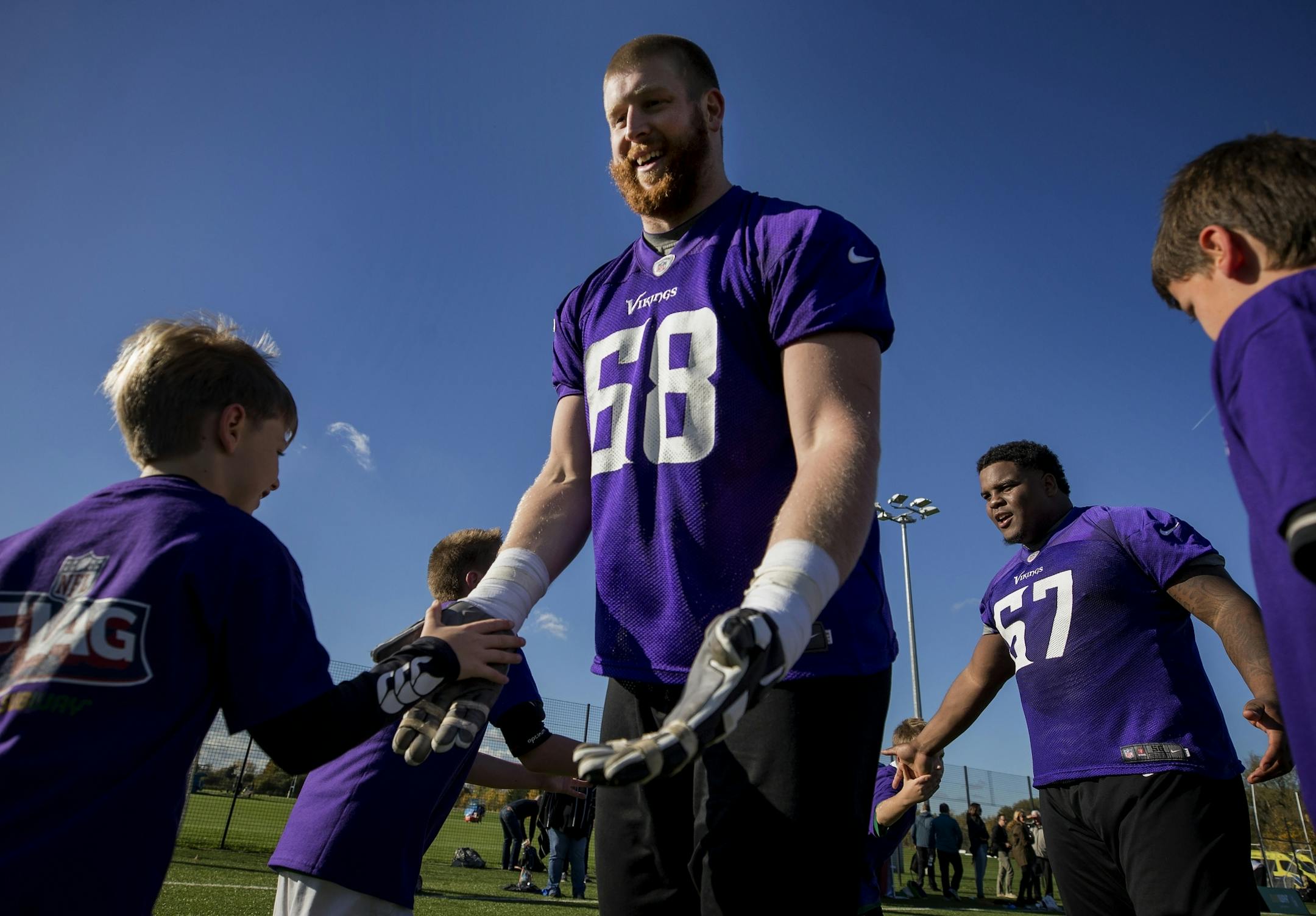Minnesota Vikings Cedrick Lang (68) and Cornelius Edison (67) greeted young athletes during an NFL FLAG event after Minnesota Vikings practice at the London Irish Training Ground.
